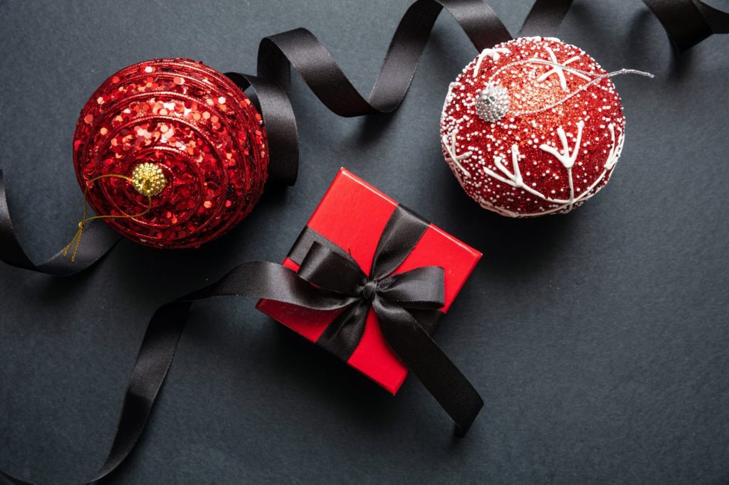 Christmas present and red xmas balls against black background, Black Friday Christmas concept.